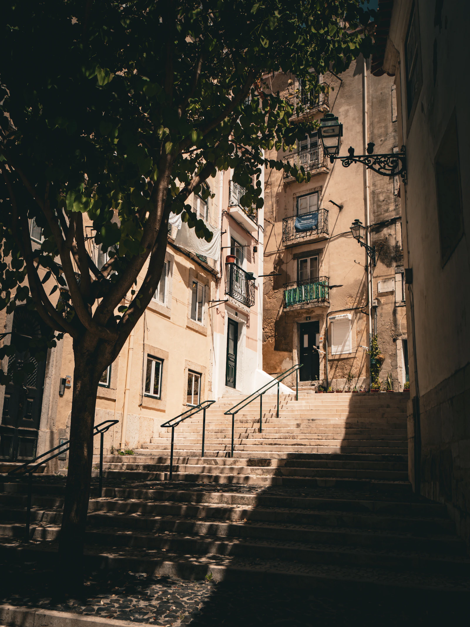 Steep stone staircase between pastel-colored buildings in Alfama