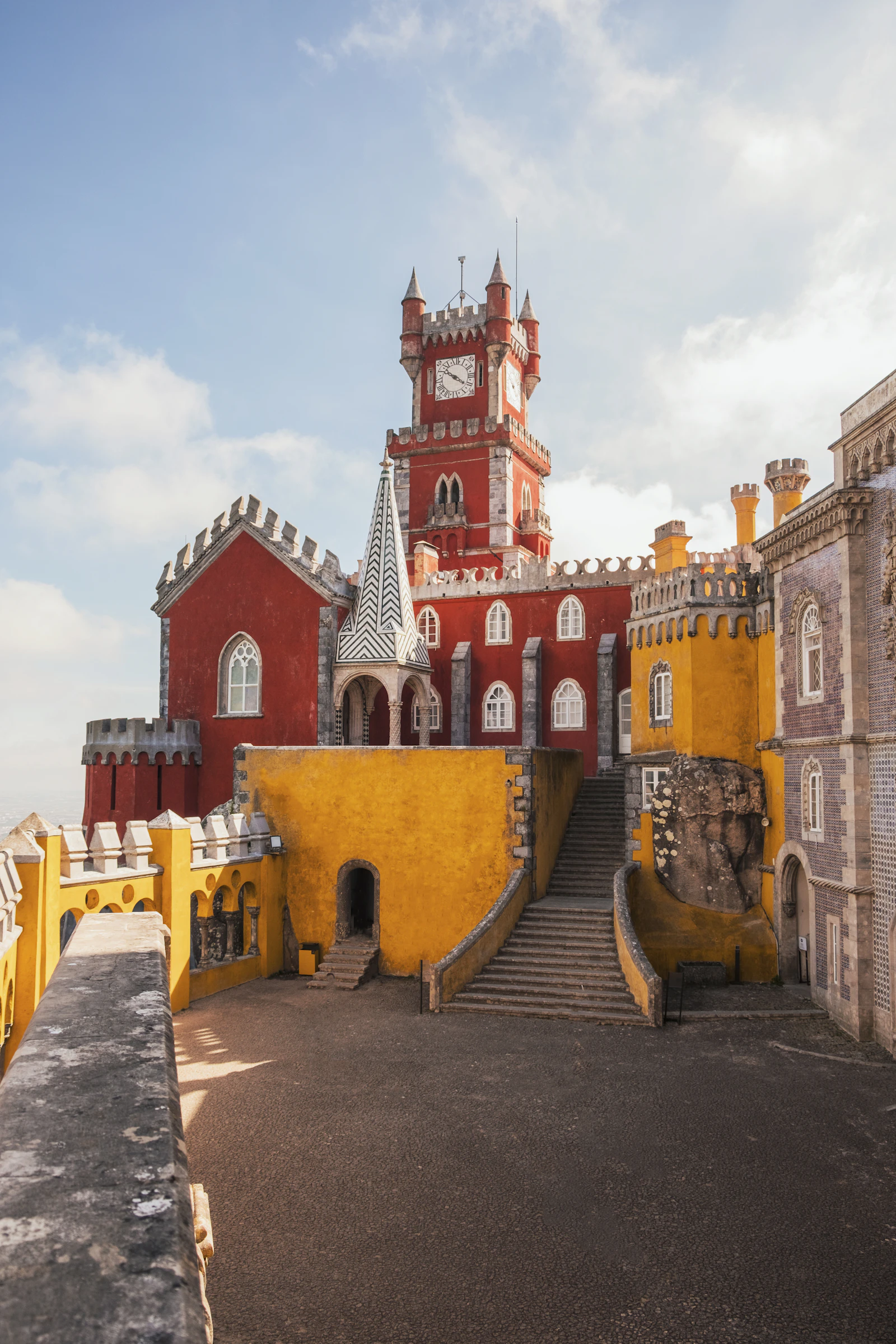 Pena Palace in Sintra with vibrant red and yellow façades against deep blue sky