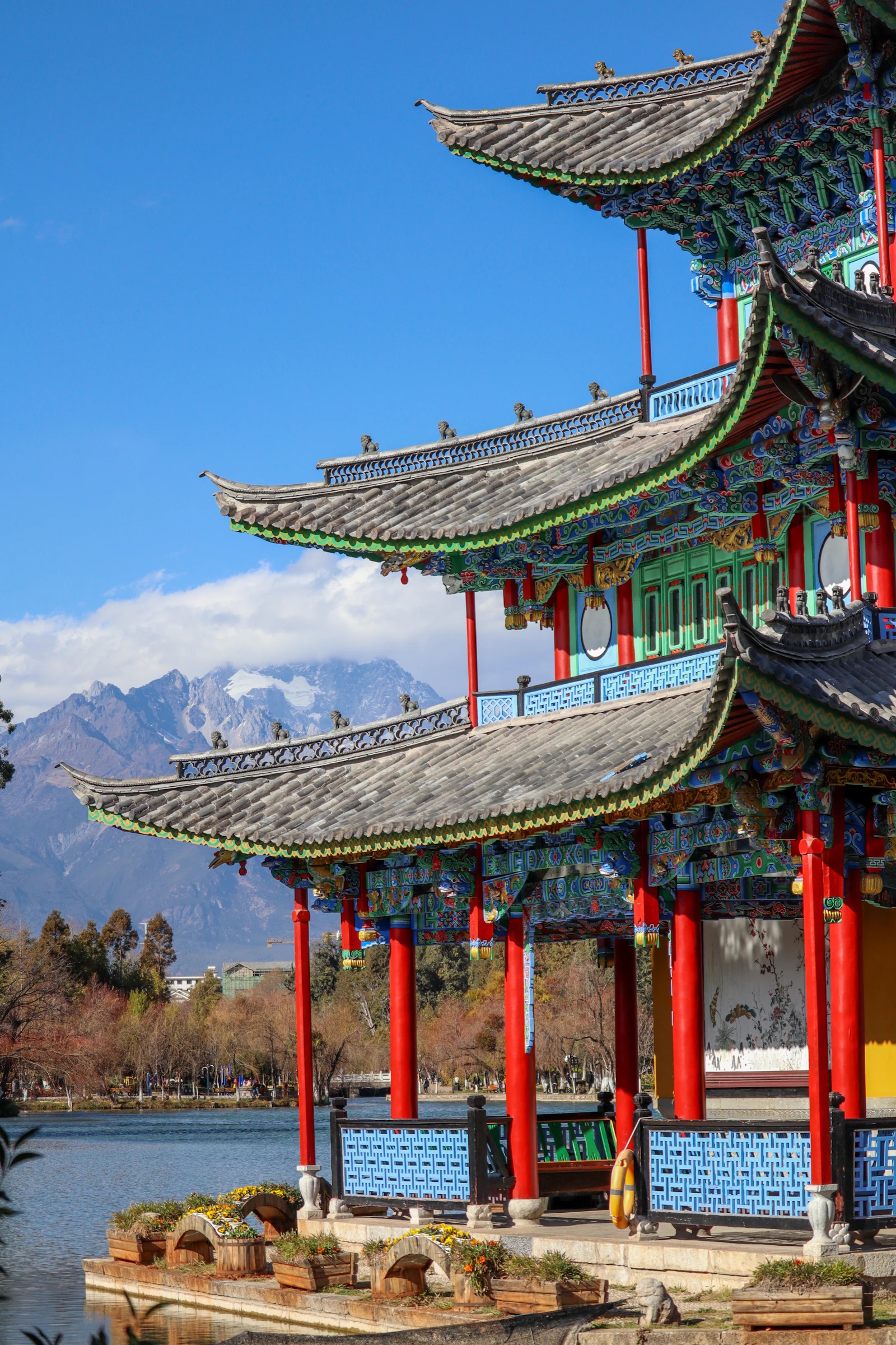 丽江玉龙雪山下，古寺屋檐与远峰相映